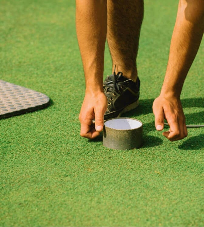 man fixing golf hole